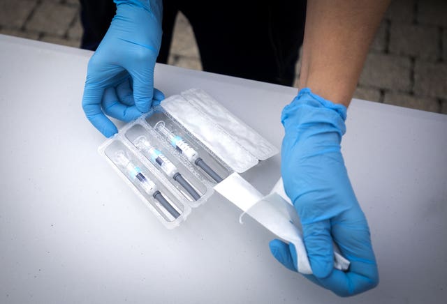 A nurse preparing flu vaccine jabs