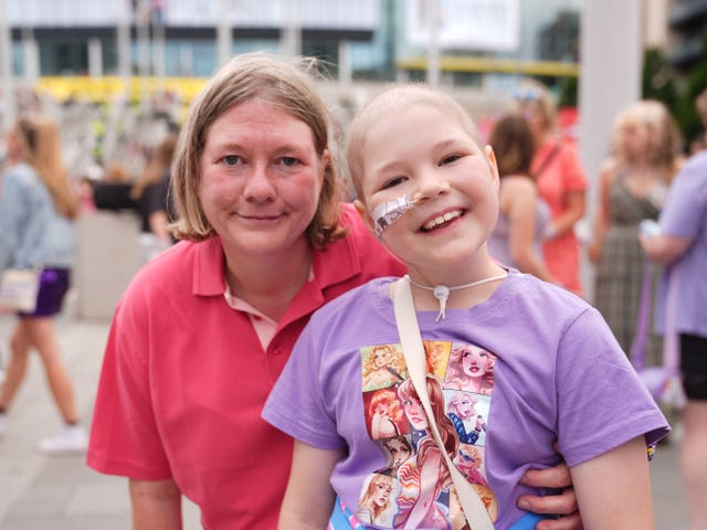 Sophie Hutton wearing a purple Taylor Swift T-shirt while her mother Angela puts her arm around her