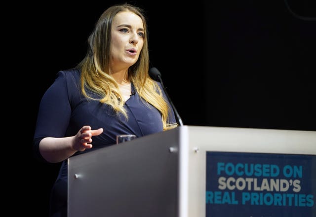 A woman in a blue dress behind a lectern