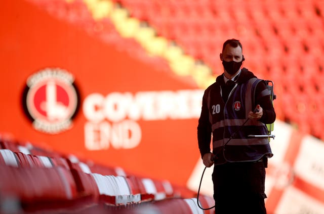 A steward disinfects the seats after the game at The Valley