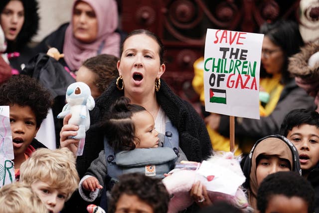 Parents and children lay out cuddly toys across the entrance to the Foreign Office in London, as they protest to save children’s lives in Gaza