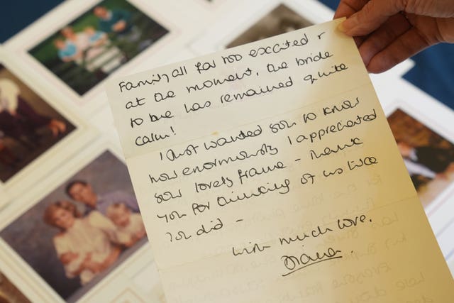 Hands holding a letter in front of a photo album