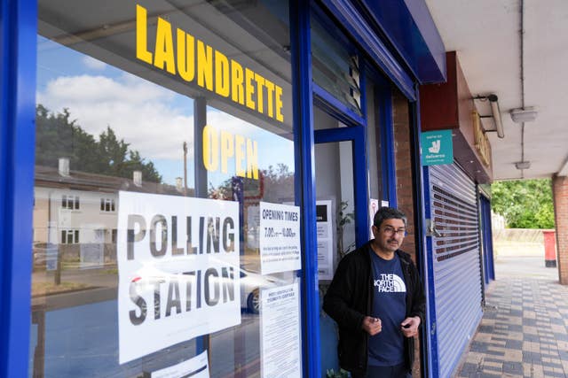 A man leaves a polling station in a laundrette