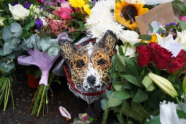 Floral tributes surround a wicker model corgi left at the gates of Balmoral Castle in Aberdeenshire 