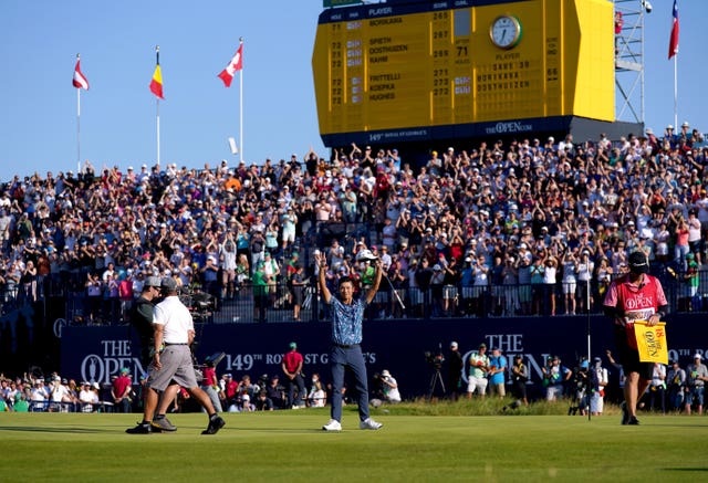 Collin Morikawa celebrates on front of packed grandstands around the 18th green