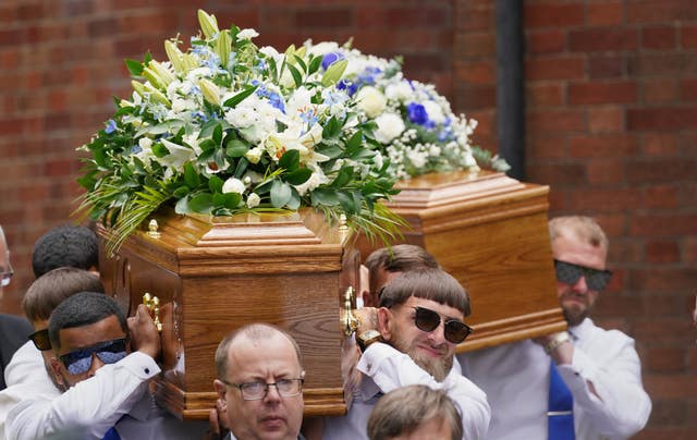 The coffins of Kyrees and Harvey are carried out of church after their funeral service in July