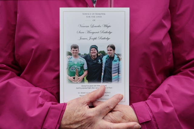 The order of service is held by a mourner 