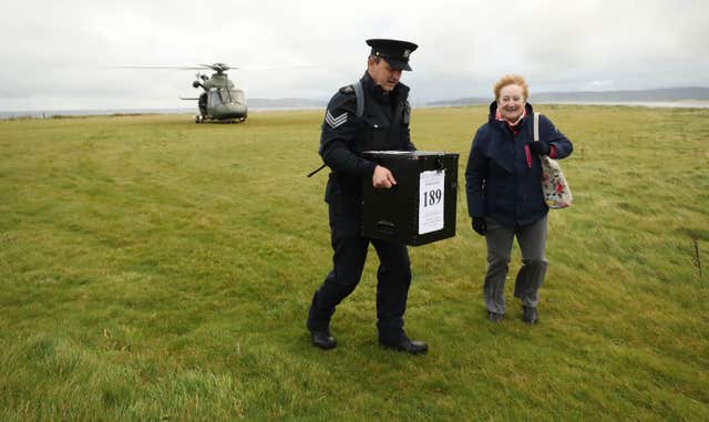 Garda Sgt John Gallagher and presiding officer Carmel McBride deliver a ballot box to Inishbofin Island