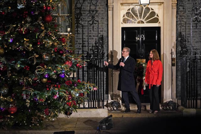 Prime Minister Sir Keir Starmer and his wife Lady Victoria Starmer in Downing Street next to a Christmas tree