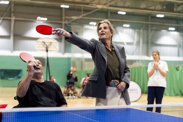 The duchess stretches with her bat to hit the ball as she plays table tennis during a visit to Stoke Mandeville Stadium