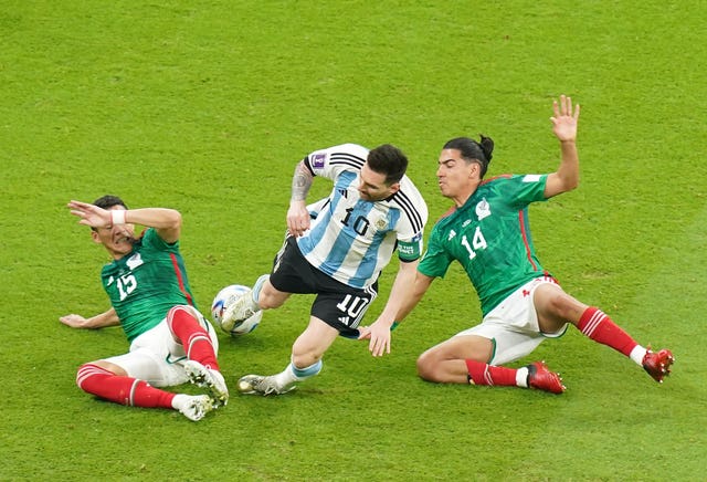 Lionel Messi is brought down by Hector Moreno, left, and Erick Gutierrez
