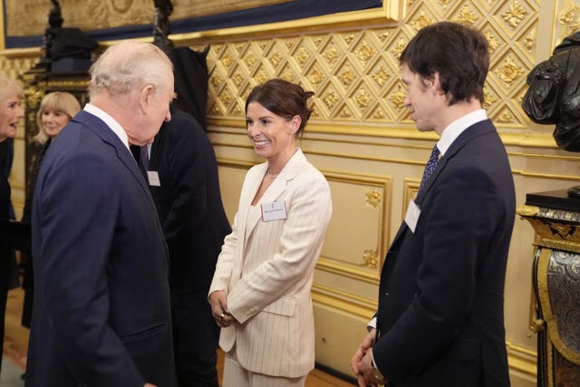 The King speaks to Coleen Rooney during the reception at Windsor Castle