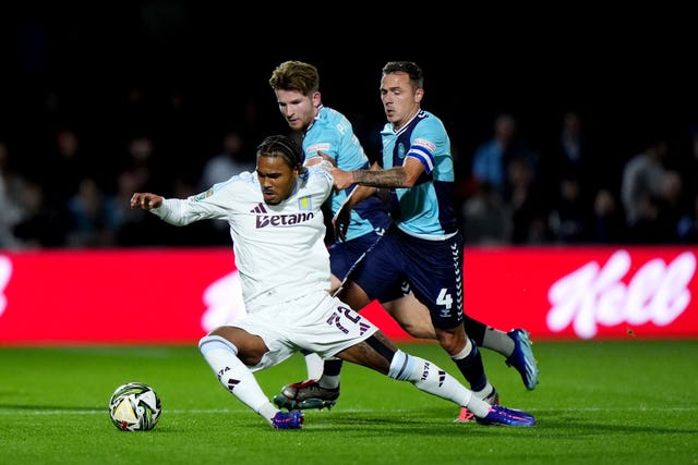 Aston Villa's Kadan Young, left, is pulled back by Wycombe's Josh Scowen