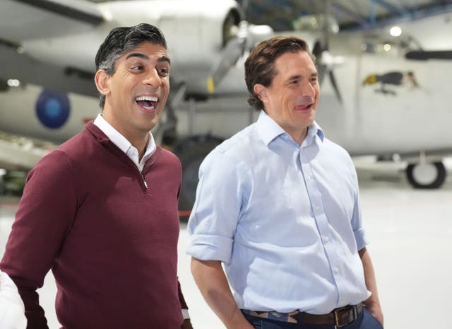 Rishi Sunak and Johnny Mercer smile while standing in front of aircraft 