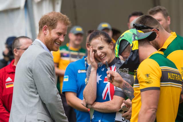 The Duke of Sussex reacts as Australian Invictus Games athlete Benjamin Yeomans puts a pair of swimming trunks on his head 