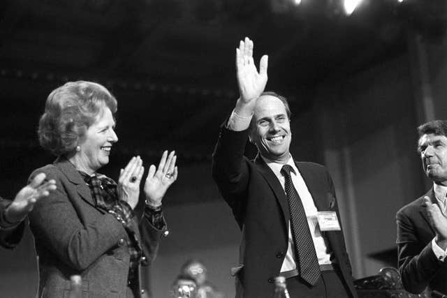 Margaret Thatcher applauds a waving Norman Tebbit after his speech at the opening of the annual Tory conference at the Winter Gardens in Blackpool in 1985