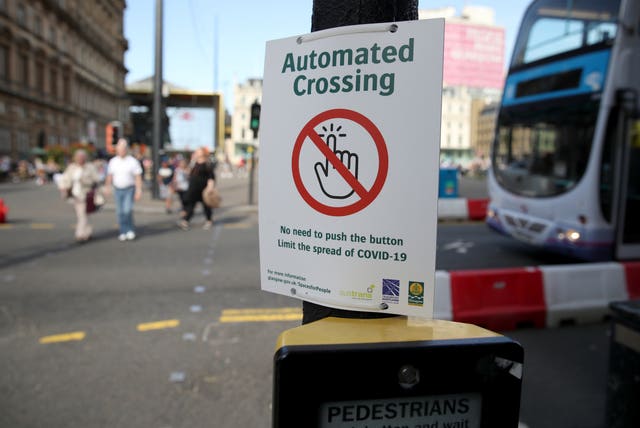 A sign to limit the spread of Covid-19 through shared contact at a crossing point in Glasgow city centre, some six months on from the evening of March 23 when Prime Minister Boris Johnson announced nationwide restrictions 