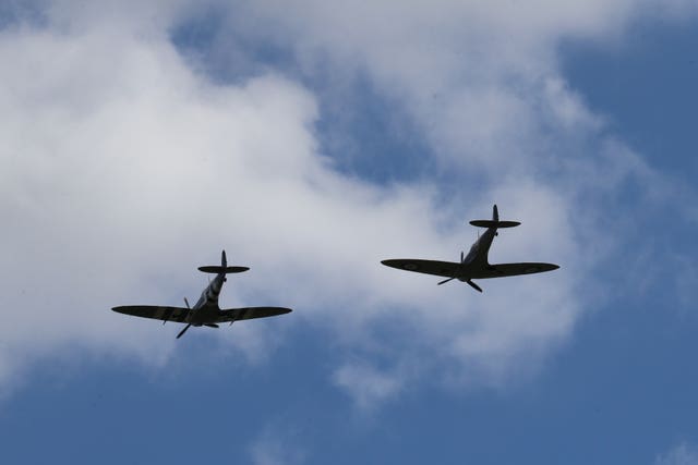 Two spitfires from the Battle of Britain Memorial flight pass overhead 