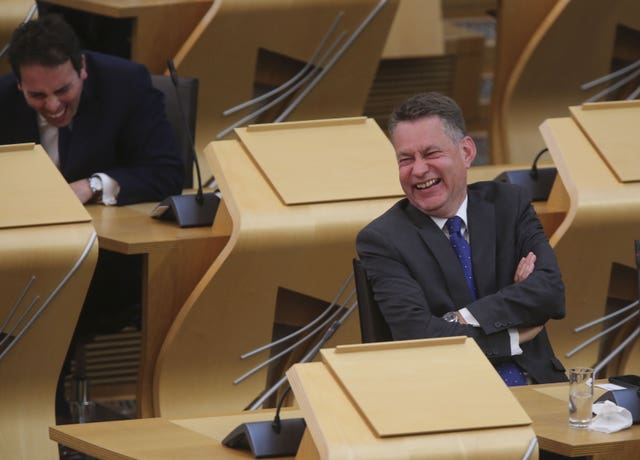 Murdo Fraser laughing while seated in the Holyrood chamber