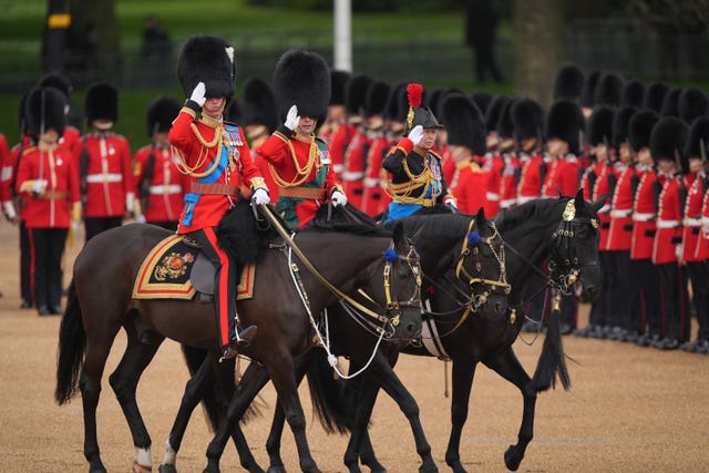 The Prince of Wales, Duke of Edinburgh and the Princess Royal ride horses and salute during the Trooping the Colour ceremony