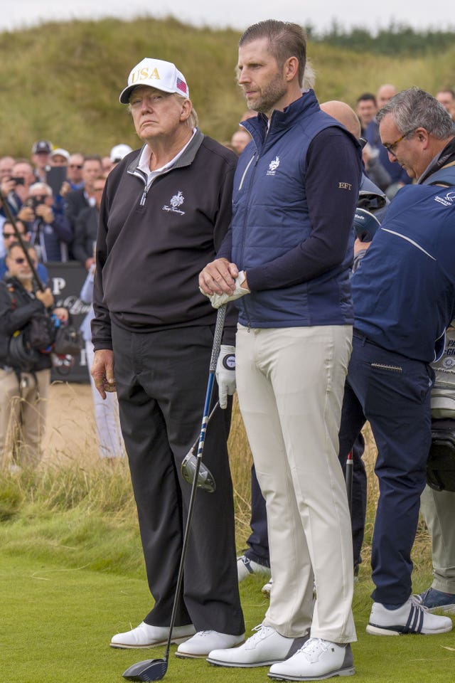 Donald Trump standing next to his son Eric, on a golf course