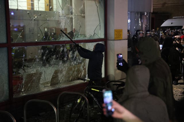 A protester smashing a window at Bridewell Police Station 